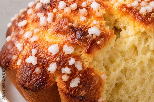 Très gros plan sur une tranche de pastis landais révélant une mie aérienne, moelleuse et une croûte caramélisée au sucre