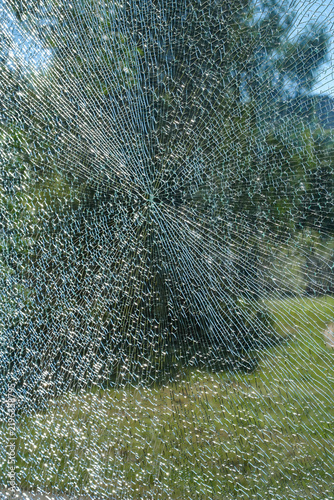 Fotografie Close up of shattered glass with cracks and radial fracture pattern
