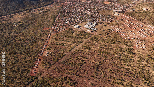 Aerial view of a large-scale affordable housing development expanding into the rural landscape with rows of small houses and dirt roads in Thabazimbi, Limpopo, South Africa.