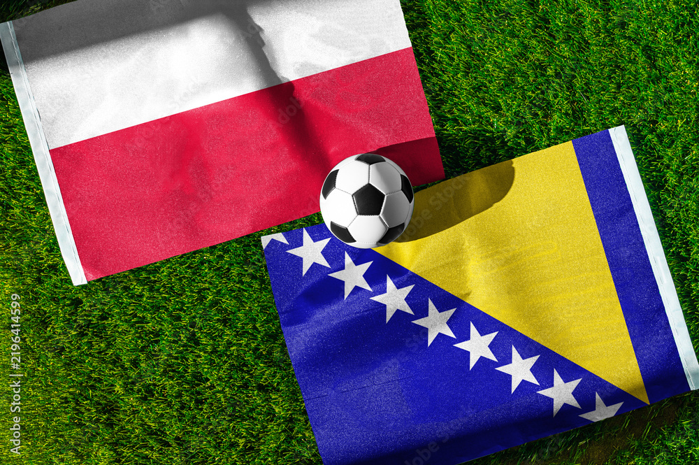 Obraz premium Poland vs. Bosnia and Herzegovina football match. National flags on green grass with soccer ball in the middle. Football background for international match.