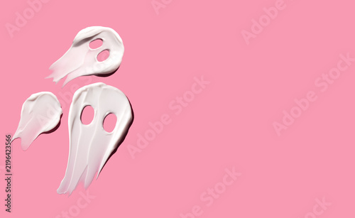 Ghosts in the form of a smear of cosmetic cream for Halloween on a pink background. Copy space. Halloween concept. Halloween for self-help.