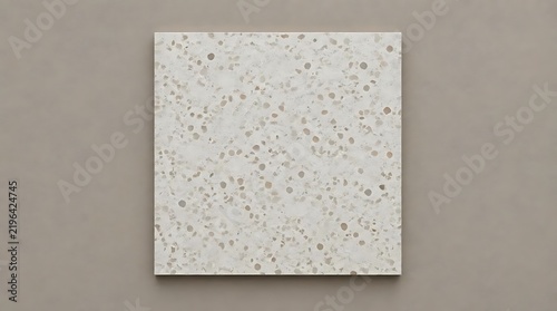 Square terrazzo tile sample with neutral stone pattern on beige background for modern interior design and architectural material presentation.