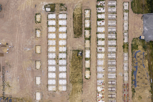 Aerial view of BESS construction site showing rows of concrete foundations and prepared ground for battery energy storage systems.