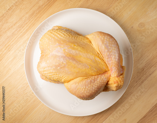 Fotografie Raw whole chicken on white plate preparing for cooking