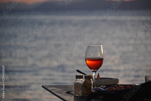 A glass of red wine by the sea, in Greece