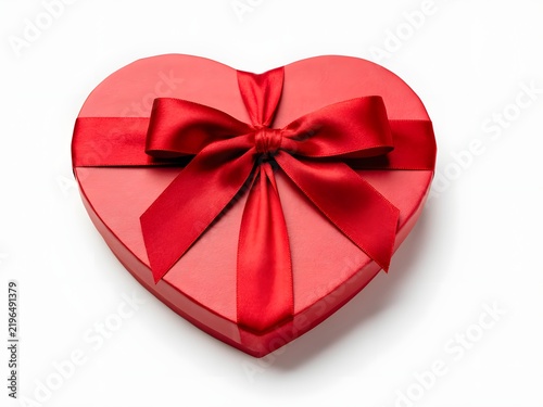 Red heart-shaped gift box with satin ribbon bow on white studio background