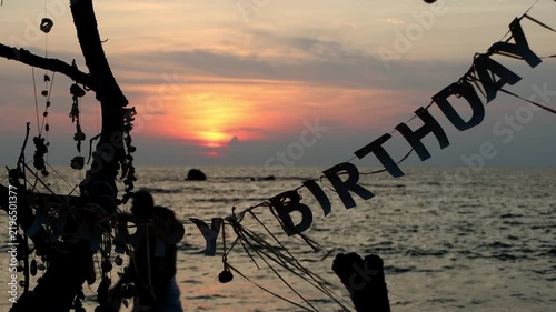 Happy Birthday Banner Hanging on a Beach Tree at Sunset