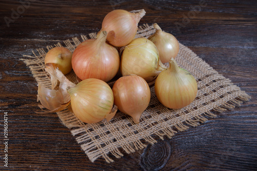 Large onion harvest on a wooden background. Bulb onion is rich in vitamins useful springLarge onion harvest on a wooden background. Bulb onion is rich in vitamins useful spring
