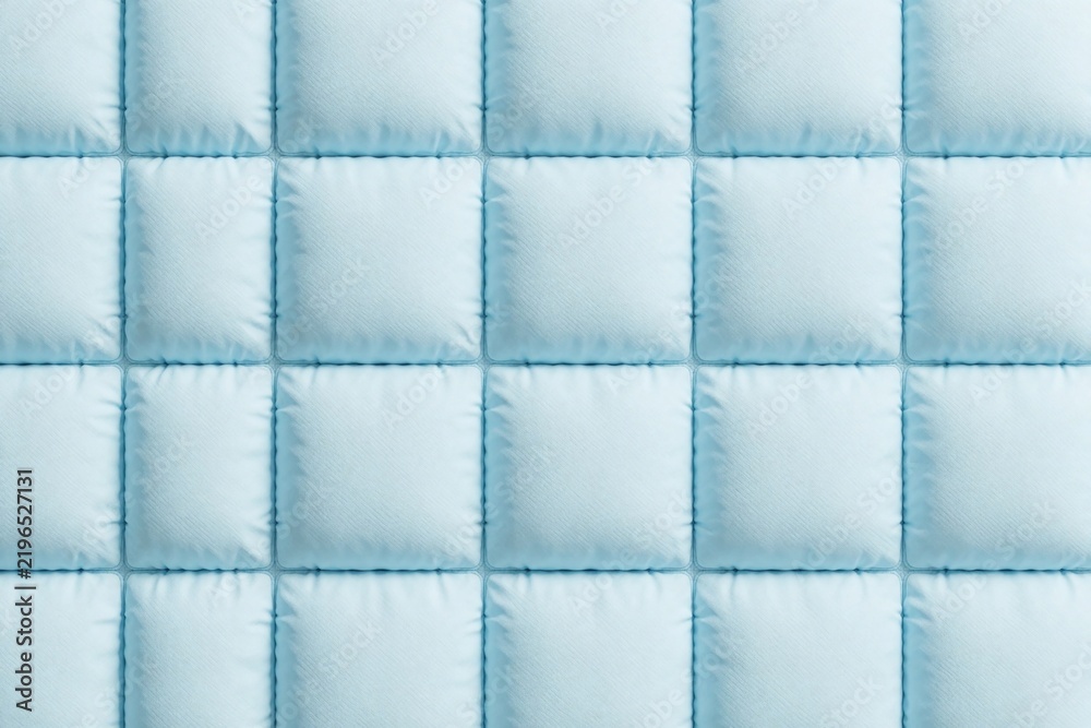 Obraz premium Light blue quilted square tiles background texture. Soft padded fabric pattern with stitched edges creates geometric surface. Minimalist interior decor element for wall upholstery design. Modern