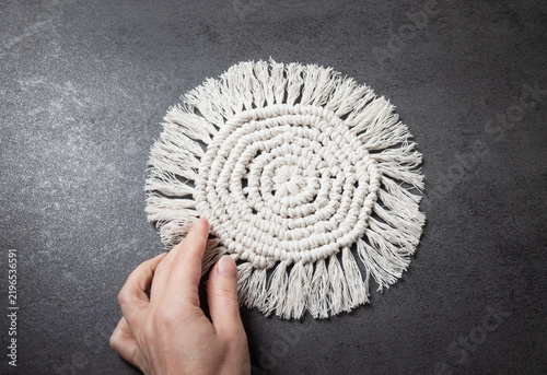 Obraz na płótnie Hands holding a white macrame piece, tactile crafting experience.