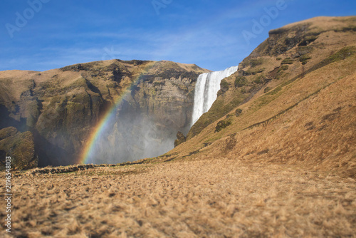 Skogafoss waterfall in Iceland with a bright rainbow
