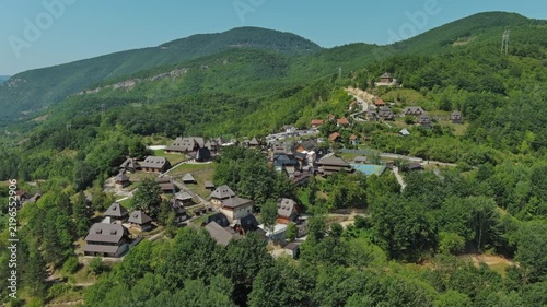 Aerial view of Drvengrad Kustendorf ethno village on Mokra Gora, Serbia, surrounded by green hills and mountains, 4k