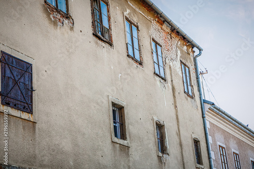 Historic building with peeling paint and a weathered facade in an urban setting during daylight