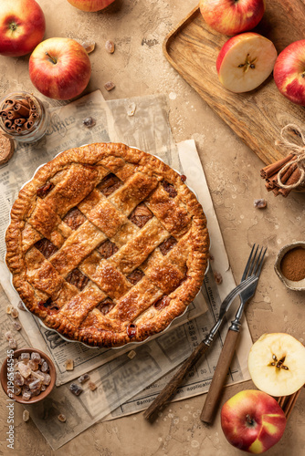 Crust Apple Pie with fresh apples on brown table background top view. Thanksgiving traditional dessert, autumn baking, recipe