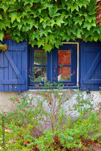 Maison aux fenêtres et volets bleus en 