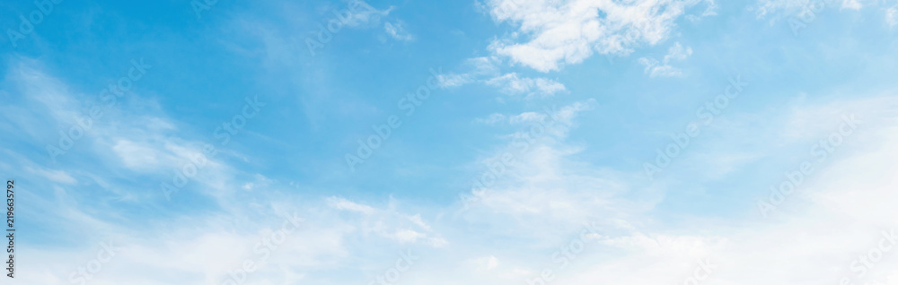 Obraz premium Soft clouds drift across clear blue sky