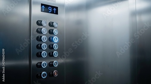A stainless steel elevator interior displays a digital control panel with numbered buttons and an indicator showing the current floor.