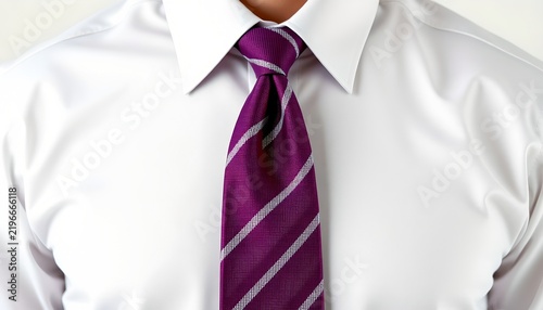 A person wearing a tie with a pattern that includes shades of purple and white. The person is dressed in a light colored shirt and dark trousers