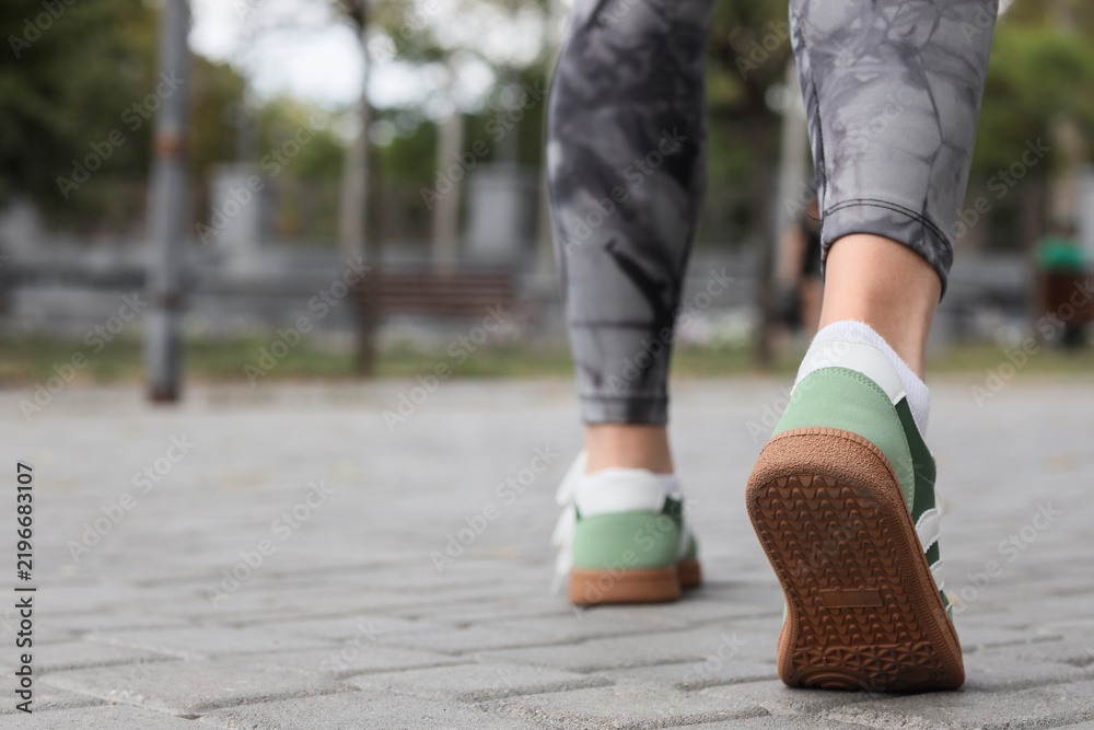 Obraz premium Healthy lifestyle and fitness, person walking in sneakers on city pavement for daily exercise and active living in an urban outdoor environment