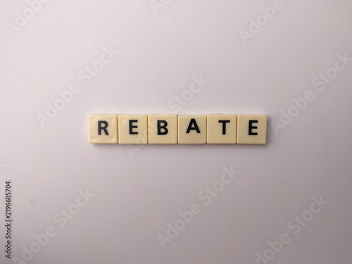 Beige letter tiles spell out the word REBATE horizontally aligned on a smooth white background