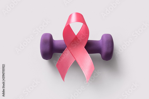 фотографія Pink ribbon and dumbbell on grey background
