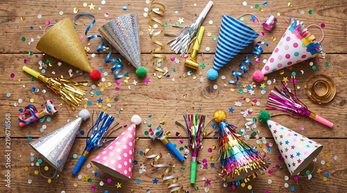 Party Hats and Confetti: A vibrant arrangement of colorful party hats, streamers, and confetti scattered across a rustic wooden surface.