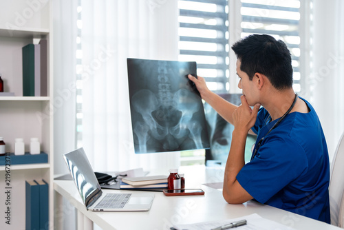Cuadro en lienzo Doctor radiology  holding x-ray film , reviewing patient diagnosis results in clinic