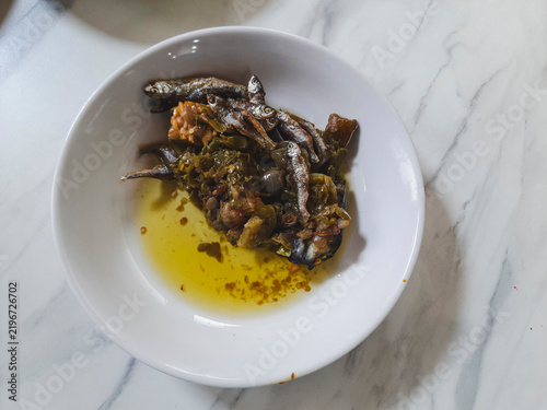 Sambal ijo with crispy fried anchovies or bilis, green chilies, shallots, garlic, and tempe served in a white bowl, a spicy traditional Minangkabau side dish in Padang restaurants local dish.