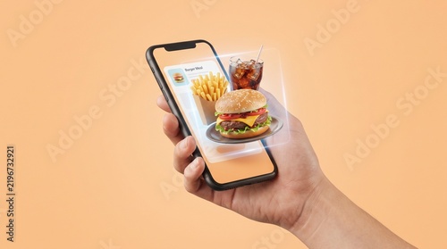 Hand holding smartphone with virtual food items with hand holds smartphone displaying virtual burger representing online food ordering digital menu