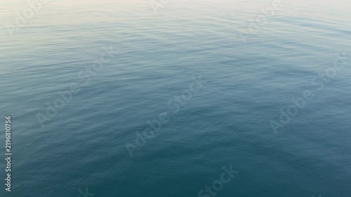 Gentle ripples on a calm sea blue water surface.