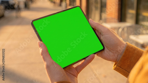Woman Hand Holding a Modern Smartphone on a City Street