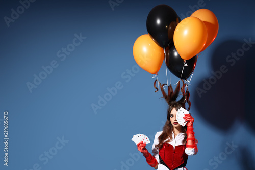 Fotografie Halloween party entertainment and magic, woman in costume holding playing cards