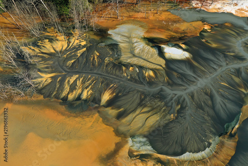 Aerial view of abstract mining pattern, nature pollution, colorful decanting lake