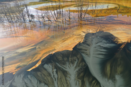 Aerial view of abstract mining pattern, nature pollution, colorful decanting lake