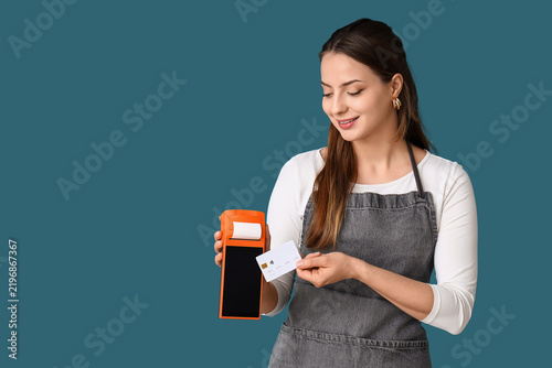 Female cashier with payment terminal and credit card on blue background