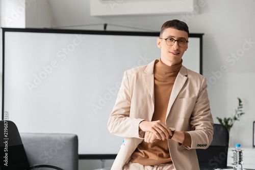 Portrait of handsome businessman with wristwatch in conference hall