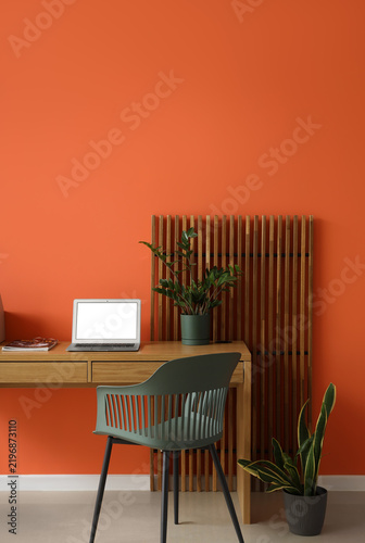 Interior of office with workplace, plants and folding screen