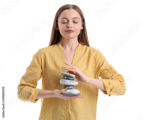 Young woman with spa stones on white background. Balance concept