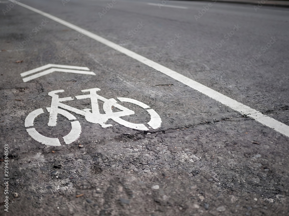Obraz premium White Painted Bicycle Lane Road Markings Indicating Designated Path for Cyclists on Urban Asphalt Street Surface