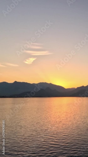 Golden Sunset Over Calm Lake and Distant Mountain Silhouette