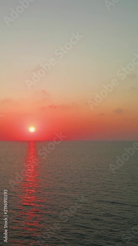 Vibrant Orange Sunset Over Calm Ocean Horizon and Coastal Water