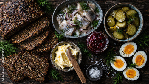 Scandinavian rye bread pickled herring dark flatlay overhead dill lingonberry Nordic smorgasbord rustic wood authentic cuisine food