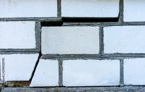 Картината върху платно Cracked white wall shows broken tiles and deteriorating mortar