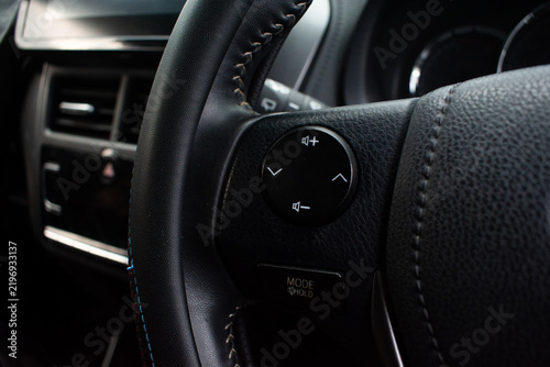Фотография Car steering wheel multifunction audio control panel in modern black vehicle int