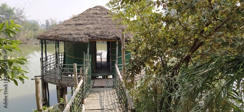Obraz na plátne Thatched roof hut on stilts over water