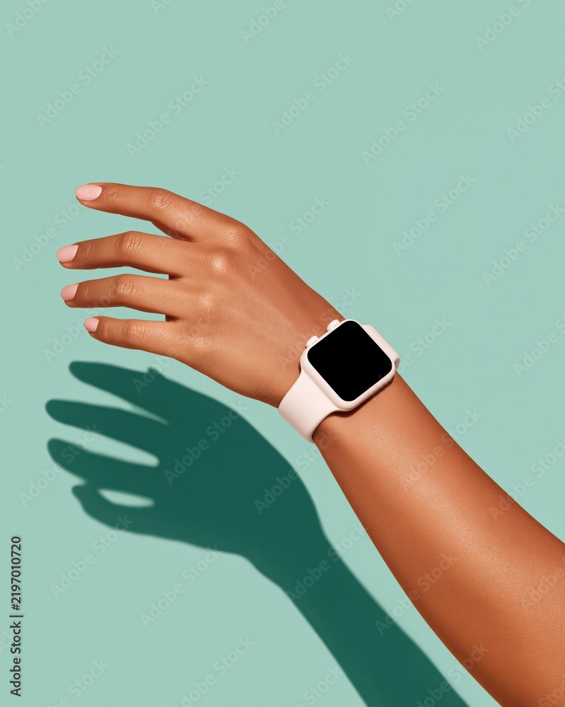 Obraz premium Hand wearing smartwatch with blank screen against mint green background