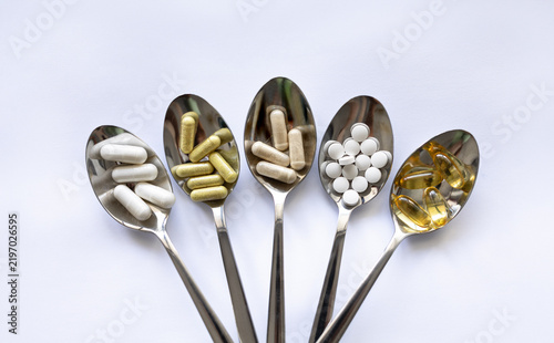 Daily fitness supplements with omega-3, creatine and vitamins on spoons