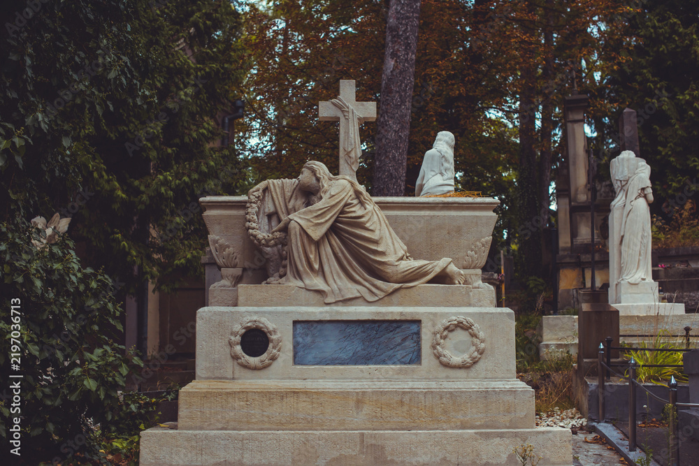 Fototapeta premium Ancient European cemetery with stone angels and historic tombstones