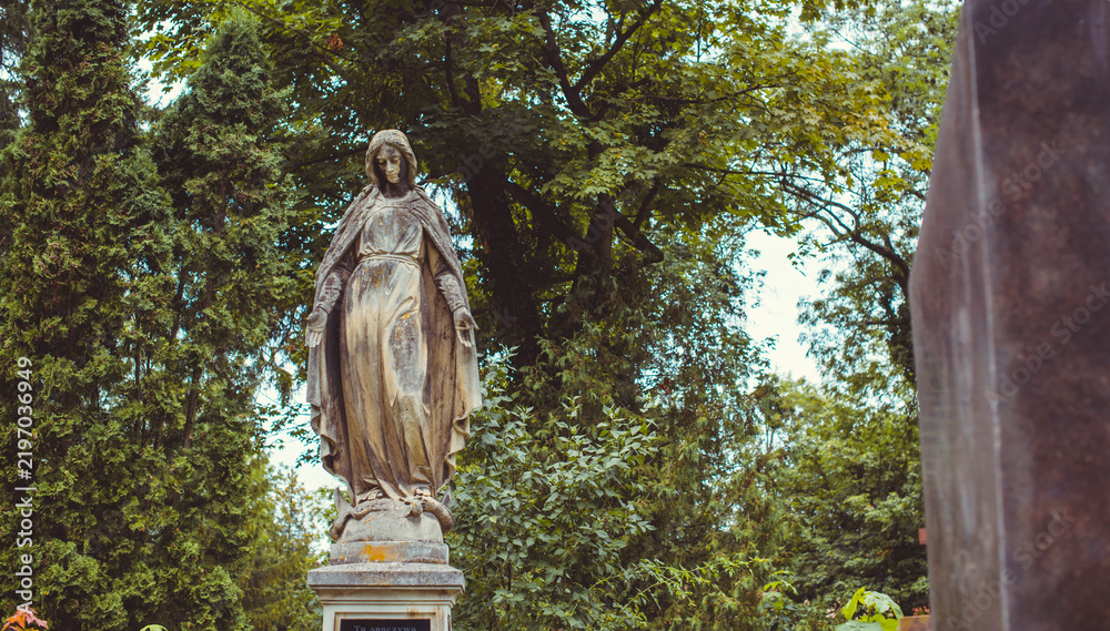 Fototapeta premium Ancient European cemetery with stone angels and historic tombstones