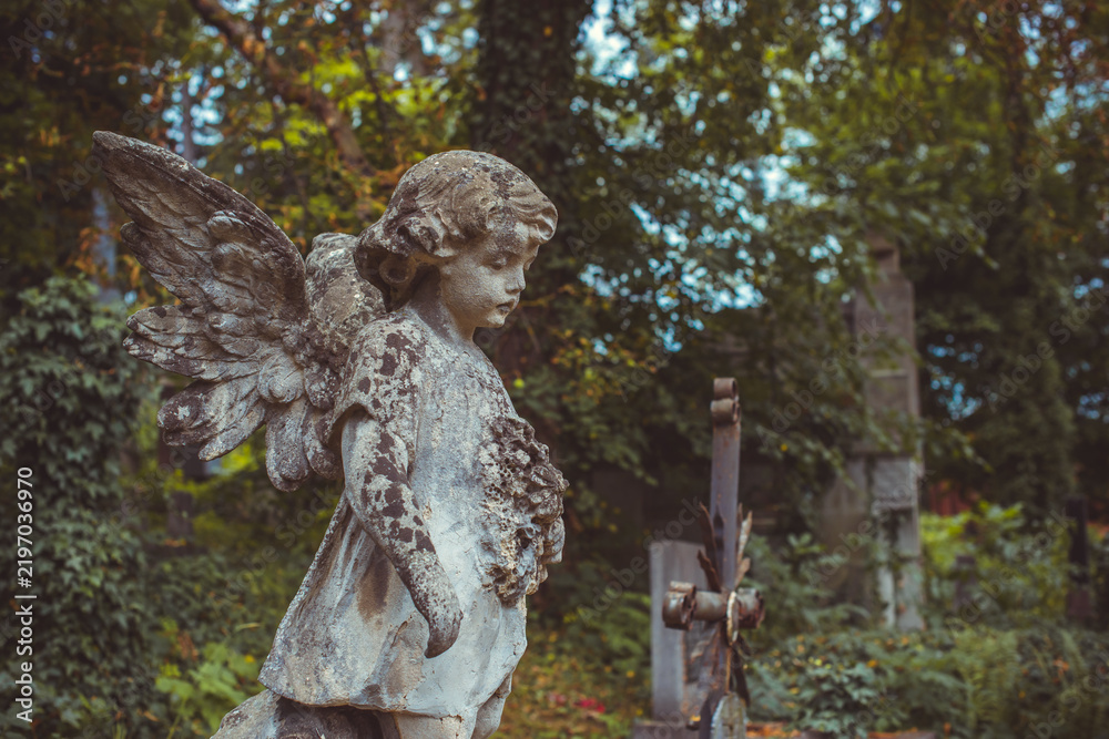 Fototapeta premium Ancient European cemetery with stone angels and historic tombstones